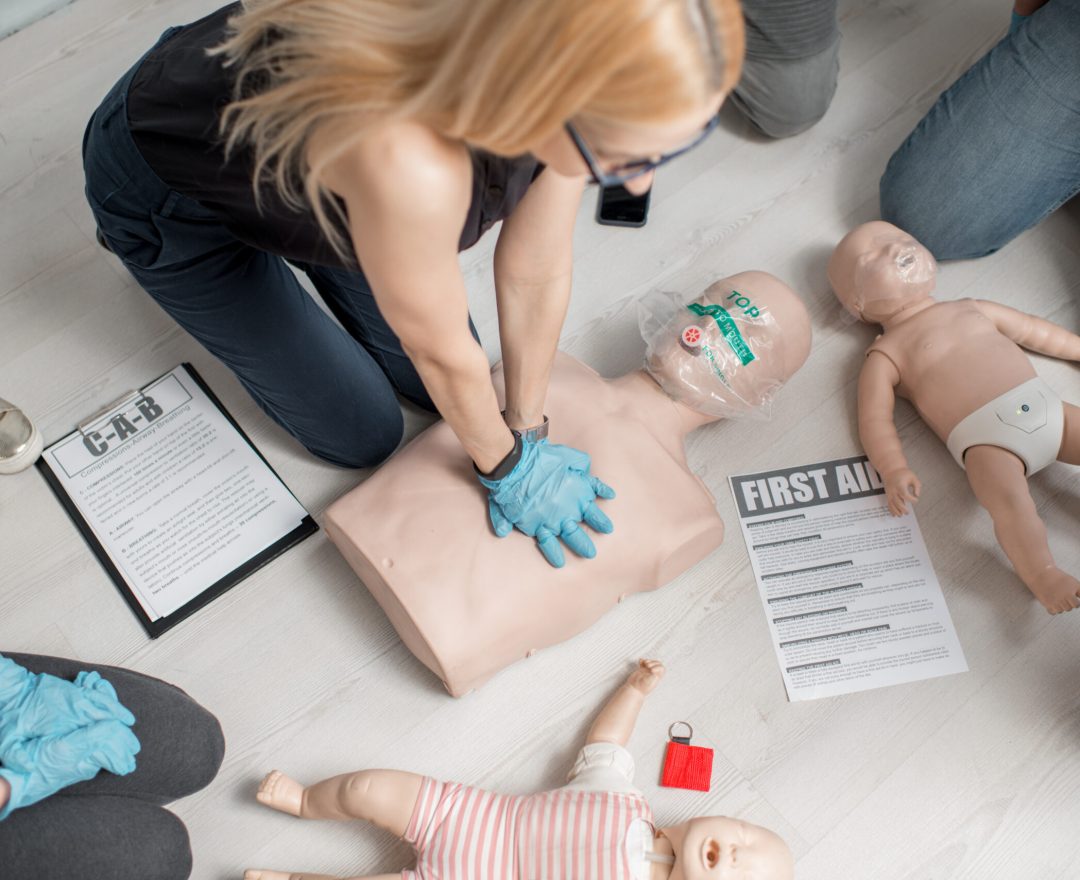 Formation d'un groupe de personnes aux gestes de premiers secours au travail et au massage cardiaque avec des mannequins d'entraînement